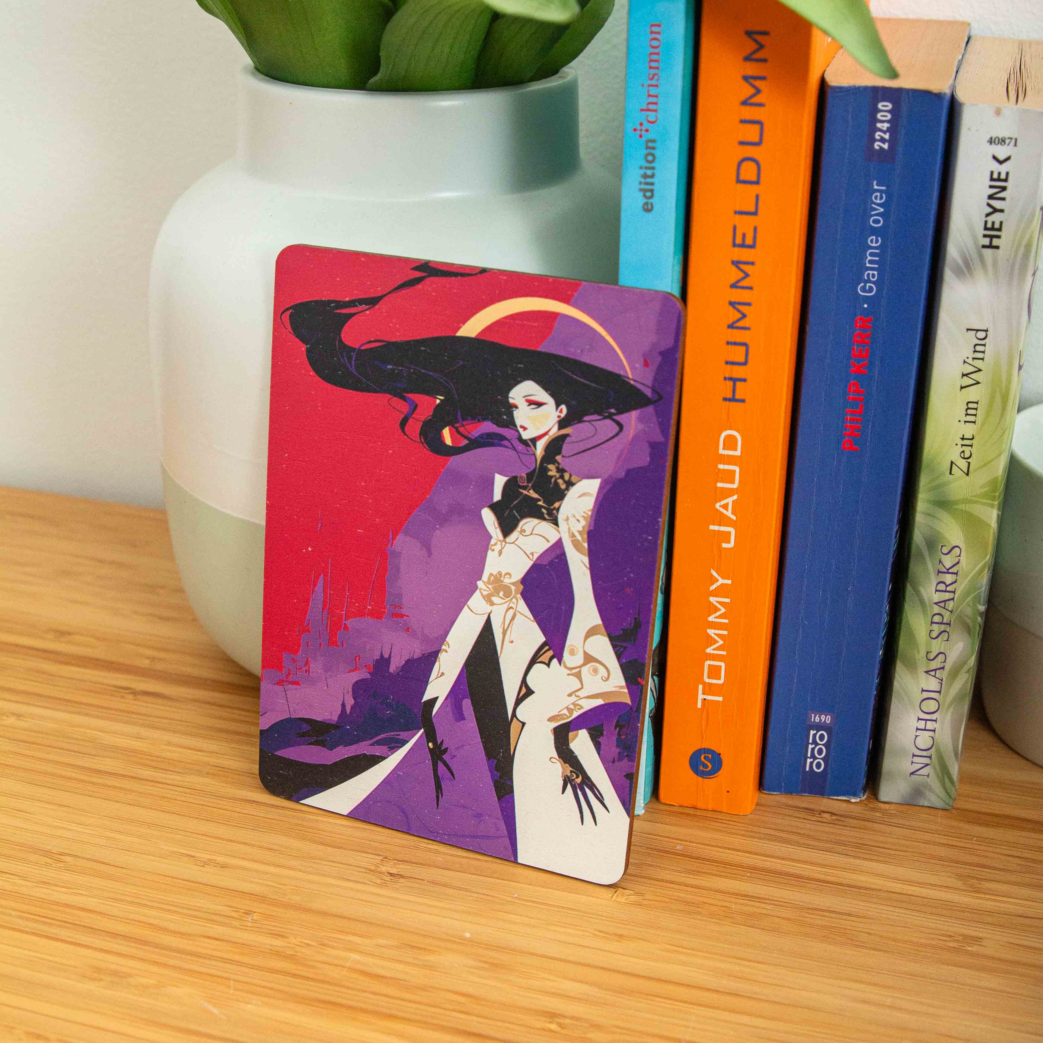 Postkarte Anime / Holzpostkarte Bücherliebhaber / Bookstagram / Postkarten mit Botschaft 4 Eine rechteckige Holzpostkarte im Hochformat liegt flach auf einer hellbraunen Holzoberfläche. Die Karte zeigt eine vollflächige, dramatische Fantasy-Illustration im modernen, kantigen Graphic-Novel-Stil. Im Zentrum steht eine elegante weibliche Figur mit extrem langem, fließendem schwarzen Haar und auffälligem roten Make-up. Sie trägt ein stilisiertes weißes Gewand mit goldenen Ornamenten und weiten Ärmeln, kombiniert mit schwarzen Elementen und langen, spitzen Fingern.